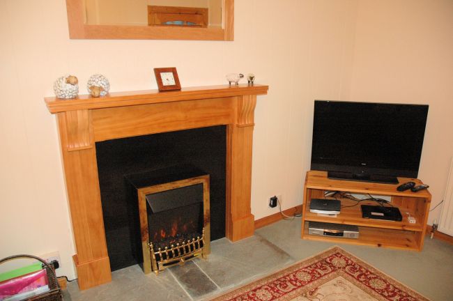 The sitting room in Bruaich Cottage, Lochcarron is cosy with a traditional fireplace and has splendid views.